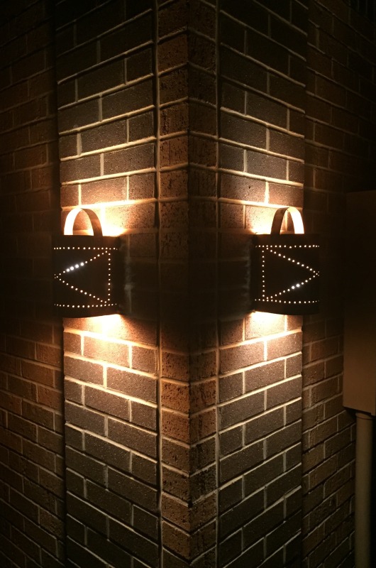 2 copper lanterns one on either side of wall